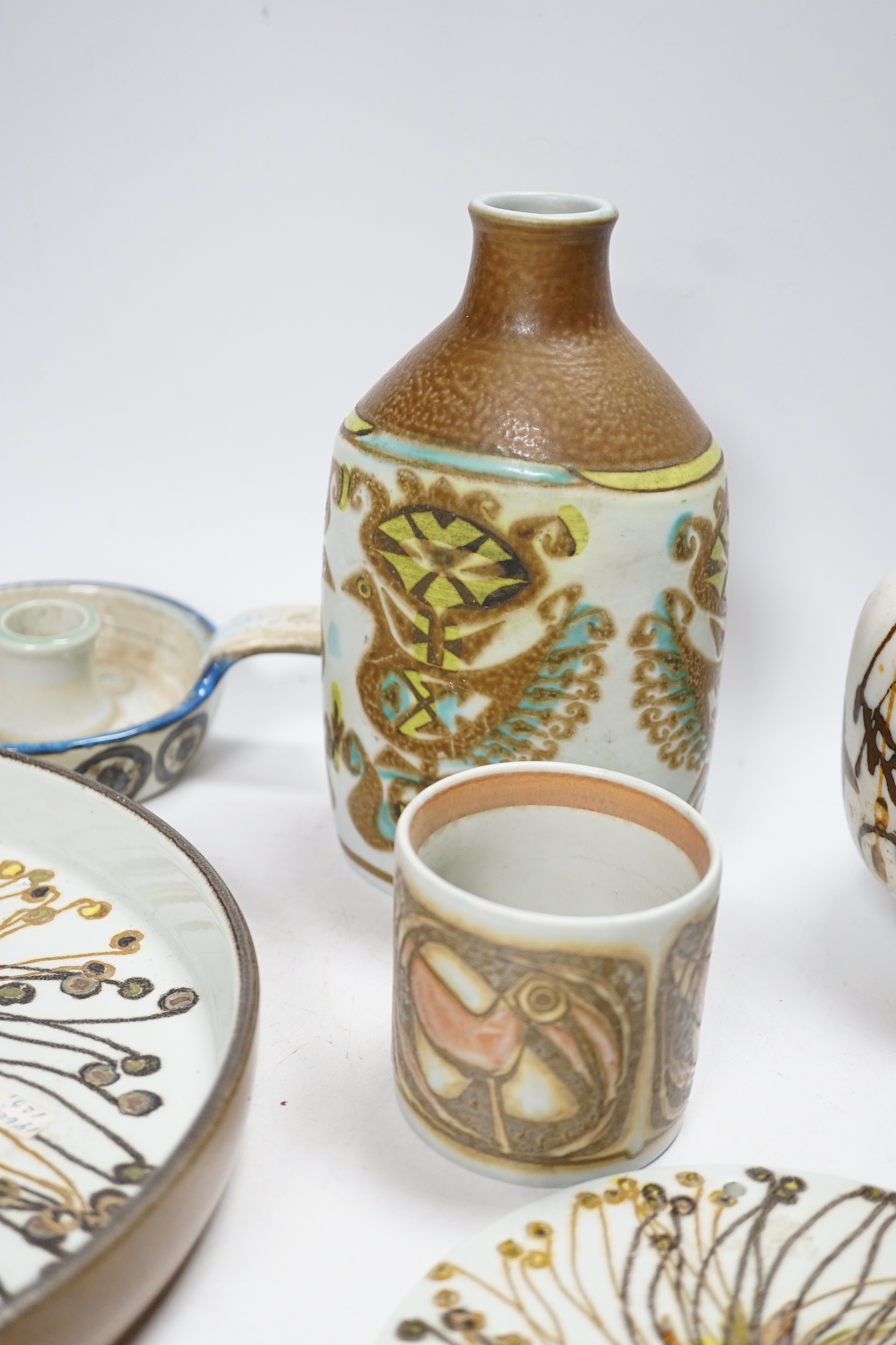 Seven Royal Copenhagen fajance items; a vase decorated with birds, a vase, decorated with fish, a small pot, a holder, two circular dishes and a teapot stand, largest dish 26cm diameter